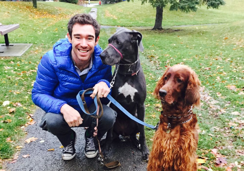 A picture of Dr. Julian  taking a pair of dogs for a walk